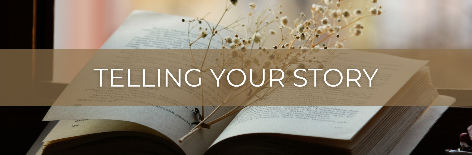 Open book with wildflowers and text 'Telling Your Story'